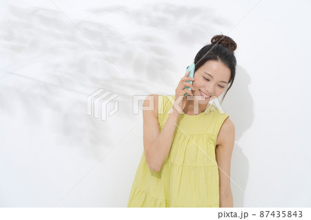 電話をかける女性 白背景 電話をかける女性 白背景 87435843