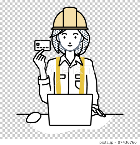 A woman at a construction site sitting at a desk and using a PC while holding a credit card 87436760