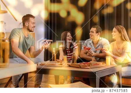 Group of friends having fun party with delicious pizza in cafe, bokeh effect 87437585