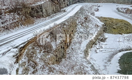 Snow covered gravel road at rock quarry Snow covered gravel road at rock quarry 87437798