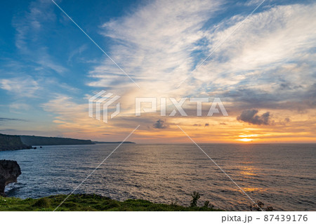 南の島の岬から見る水平線に沈む夕日 87439176