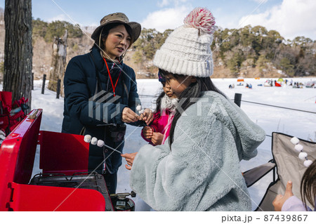 キャンプで焼きマシュマロを作る子供 87439867