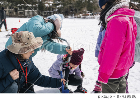 ワカサギ釣り 全面結氷した湖に穴をあける小学生 ワカサギ釣り 全面結氷した湖に穴をあける小学生 87439986