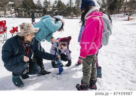 ワカサギ釣り 全面結氷した湖に穴をあける小学生 ワカサギ釣り 全面結氷した湖に穴をあける小学生 87439987