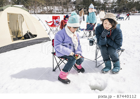 氷上でワカサギ釣りをする女の子　冬キャンプ 87440112