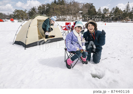 氷上でワカサギ釣りをする女の子　冬キャンプ 87440116