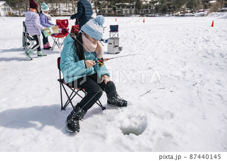 氷上でワカサギ釣りをする女の子　冬キャンプ 87440145