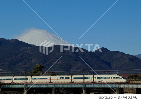 雪を抱いた富士山をバックに酒匂川橋梁を渡るVSEロマンスカー 87440346