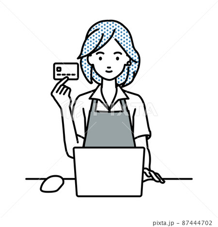 デスクで座ってPCを使いながらクレジットカードを手に持っているカフェ店員の女性 87444702