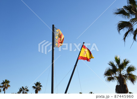 Valencian Community flag is an autonomous community of Spain. Spain flag on blue sky background. Valencian Community flag is an autonomous community of Spain. Spain flag on blue sky background. 87445960