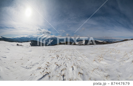 Winter remote alpine mountain village outskirts, countryside hills, groves and farmlands. Winter remote alpine mountain village outskirts, countryside hills, groves and farmlands. 87447679