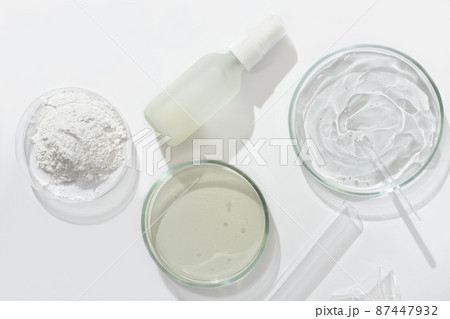 top view of cosmetic product in glass bottle and petri dish with medium and test tube on a laboratory table. lab research on skin care cosmetic ingredients and product safety 87447932
