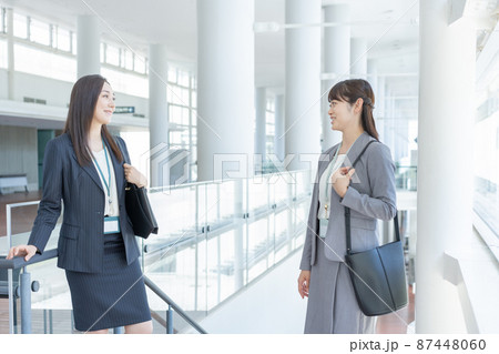 ビジネス　オフィスの通路に向かい合って立つ2人のビジネスウーマン 87448060