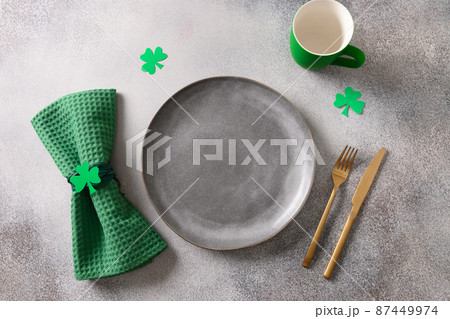 St Patrick's Day party table setting decorated with green leprechaun on gray background. 87449974