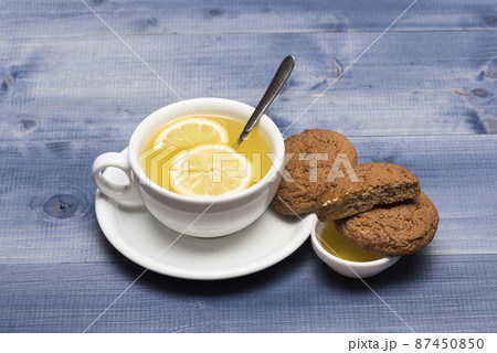Cookies near tea on grey wooden background. 87450850