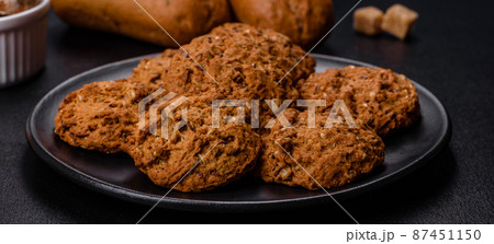 Tasty fresh oat cookies on a dark concrete background 87451150