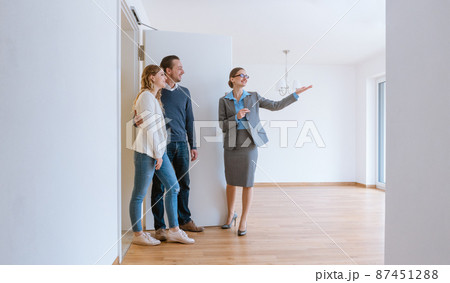 Realtor showing house to a young couple Realtor showing house to a young couple 87451288