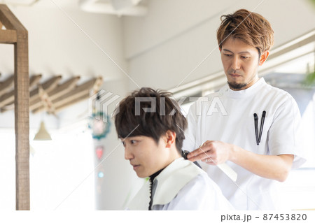 理容室でヘアカットしてもらう男性 87453820