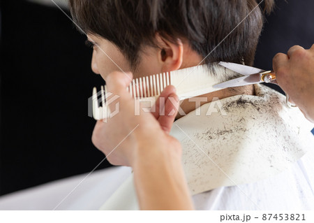 理容室でヘアカットしてもらう男性 87453821