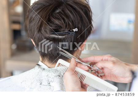 理容室でヘアカットしてもらう男性 87453859