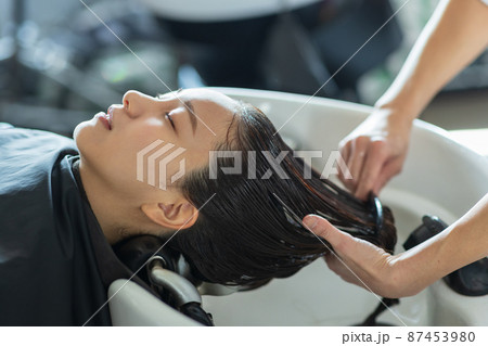 美容室でシャンプーしてもらう女性 87453980