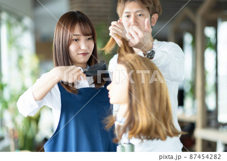 ヘアカットの練習をする女性 87454282