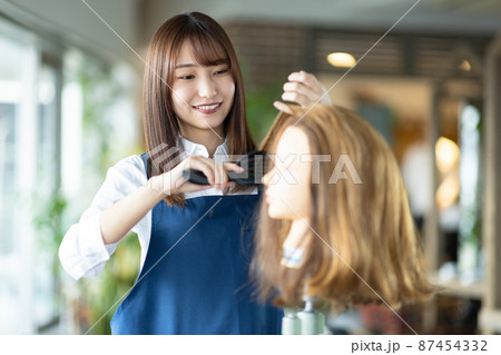 ヘアカットの練習をする女性 87454332