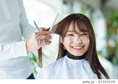 ヘアカットしてもらう可愛い女性 87454528