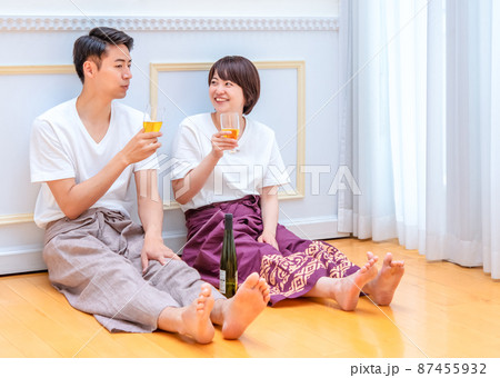 床に座ってグラスを傾けるカップル 床に座ってグラスを傾けるカップル 87455932