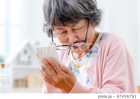 老眼鏡を掛けるシニア女性 老眼鏡を掛けるシニア女性 87456791