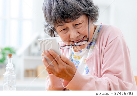 老眼鏡を掛けるシニア女性 老眼鏡を掛けるシニア女性 87456793