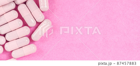 Pink capsule pills on pink background with copy space. Pink capsule pills on pink background with copy space. 87457883