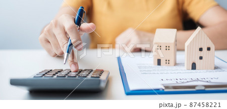Woman using calculator during signing home contract documents. Contract agreement, real estate,  buy and sale and insurance concepts 87458221