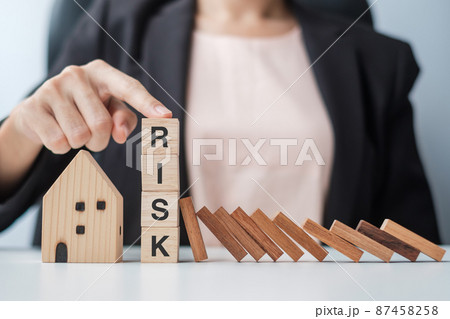 Businessman stop falling wooden blocks and protect house model. Crisis, fall Business, Risk, Economic recession, Developer, Real Estate and Property concept Businessman stop falling wooden blocks and protect house model. Crisis, fall Business, Risk, Economic recession, Developer, Real Estate and Property concept 87458258
