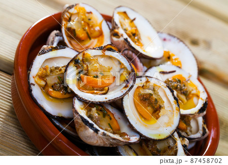 Baked in oven with sauce open seashell served at white plate 87458702