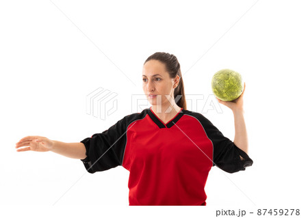 Caucasian young female handball player throwing yellow ball against white background with copy space 87459278
