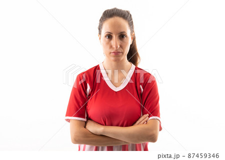 Portrait of caucasian young female player with arms crossed standing against white background 87459346