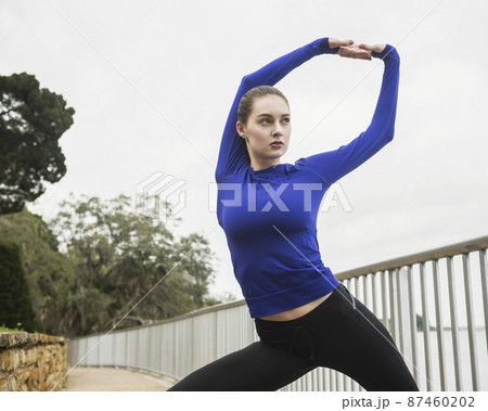 Woman stretching outdoors 87460202