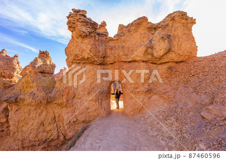 United States, Utah, Bryce Canyon National Park, Senior hiker standing in sandstone archway 87460596