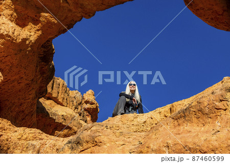 United States, Utah, Bryce Canyon National Park, Senior hiker sitting on sandstone ledge 87460599