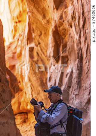 United States, Utah, Escalante, Senior hiker exploring and photographing rock formations in Kodachrome Basin State Park near Escalante Grand Staircase National Monument 87460656