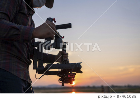 Filmmaker or content creator using stabilizer gimbal camera take video footage on the location outdoor 87461038