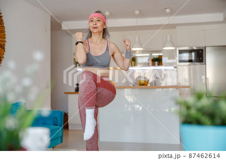 Woman in sportswear having workout in living room Woman in sportswear having workout in living room 87462614