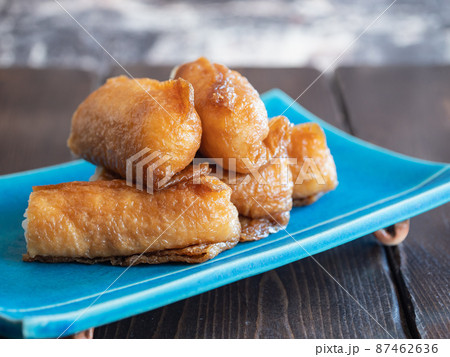 いなり寿司。酢飯を甘く煮込んだ油揚げで包んだ日本の料理。 いなり寿司。酢飯を甘く煮込んだ油揚げで包んだ日本の料理。 87462636