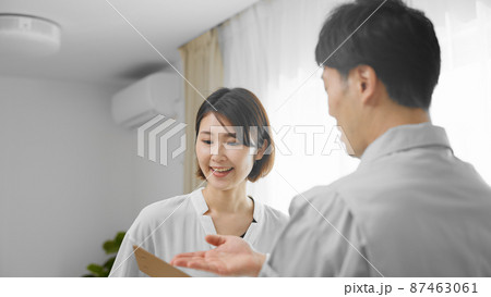 家主に説明をする作業着の男性　安全点検イメージ	 87463061