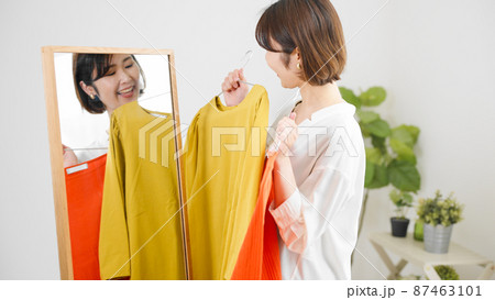 鏡の前で服選びをしている若い女性 ファッションイメージ 鏡の前で服選びをしている若い女性 ファッションイメージ 87463101