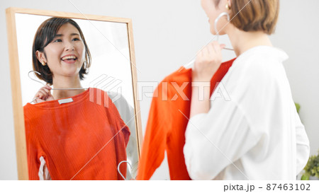 鏡の前で服選びをしている若い女性 ファッションイメージ 鏡の前で服選びをしている若い女性 ファッションイメージ 87463102
