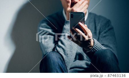 精神障害を患っている男性がスマートフォンを使っている 精神障害を患っている男性がスマートフォンを使っている 87463136