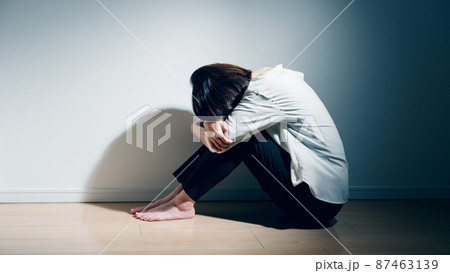 精神障害を患っている若い女性が膝を抱えているの写真素材 [87463139 
