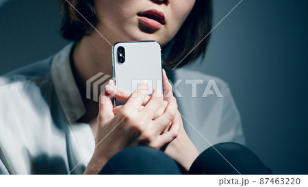 精神障害を患っている若い女性がスマートフォンを使っている 精神障害を患っている若い女性がスマートフォンを使っている 87463220